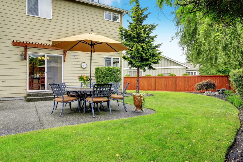 Patio area with table set and umbrella - Lime Green Lawn Care